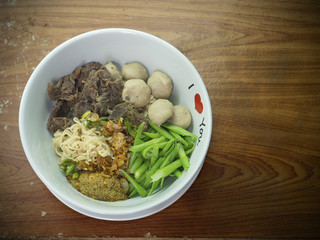 Instant nooddles with beef and meatball on wooden table