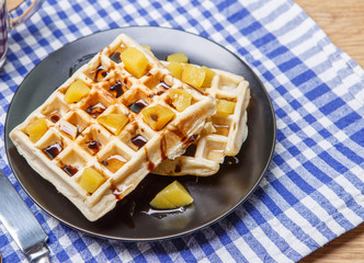 Black plate with homemade waffles, tangerines, chocolate