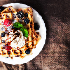 .Traditional Belgian waffles with ice cream and berry fruits on