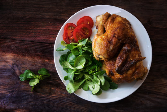 Grilled Half Chicken Dish With Tomatoes And Corn Salad, Dark Wooden Background With Copy Space, View From Above