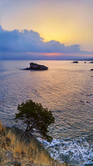 Naklejka premium Cyprus beautiful sunrise at the sea with rocks and cloudy sky, natural panoramic background. Summer vacation concept