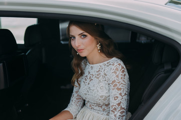 Obraz na płótnie Canvas close-up portrait of a pretty shy bride in a car window