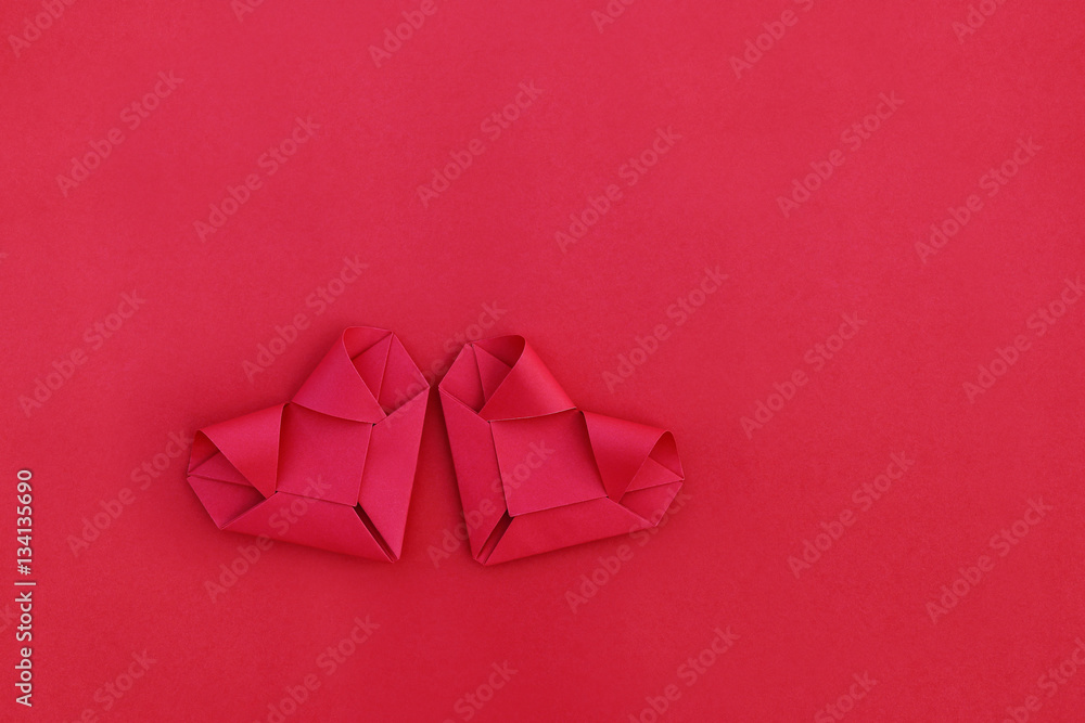 Poster two folding red paper hearts on red for pattern and background