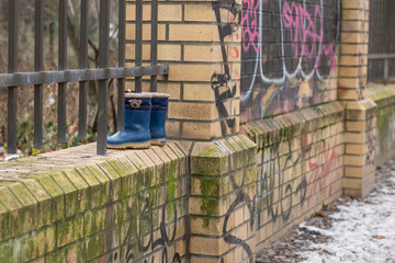 Naklejka premium Kinderstiefel auf einer Backsteinmauer