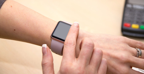 Girl using her iWatch. Close up of a finger about to swipe across a smartwatch.