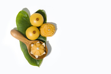 Sweet yellow desert royal Thai cuisine decorated with green leaf and wooden spoon on solid white background