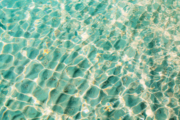 Blue clear transparent water background with sand