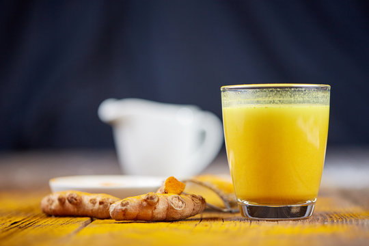 Turmeric tea golden milk with curcuma on table