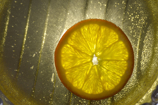Ripe orange slice of orange floating in lemonade