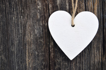 Decorative white wooden heart on old wooden background.Valentine heart.Saint Valentine's Day or Love concept.Selective focus.