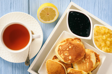 Homemade pancakes with jam and cup of tea.