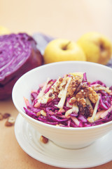 Purple cabbage salad and ingredients on a bright background. 