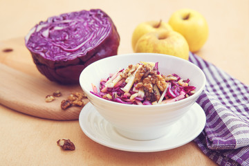 Purple cabbage salad and ingredients on a bright background. 