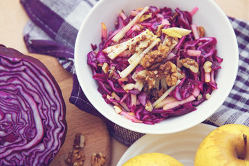 Purple cabbage salad and ingredients on a bright background. 