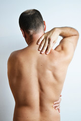 Caucasion man having back ache problems. Studio photograph.