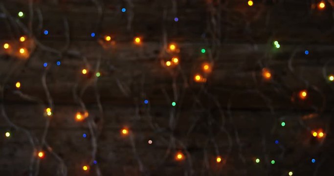 Bokeh of colorful christmas lights glowing on a plank