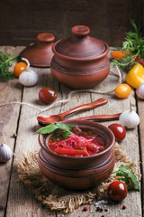 Vegetable soup in a bowl, vintage wooden background, rustic styl