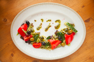 delicious greek salad on  plate on wooden background