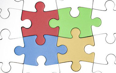 Fototapeta premium four colored pieces, white jigsaw with colored pieces in the middle. temawork, solidarity, human, hope