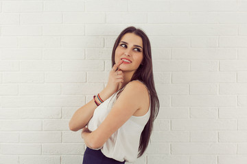 Business woman daydreaming thinking smiling white bricks wall background. Positive human emotions