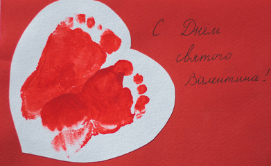 a homemade card with prints of children's feet on Valentine's day