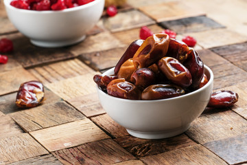 Sweet dates in bowl on wooden background, selective focus