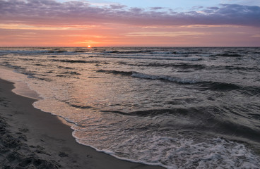 Sunset on Baltic Sea white dramatic sky and rough sea