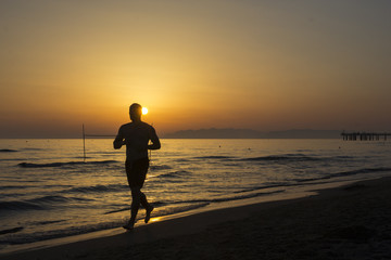 Läufer am Strand bei Sonnenuntergang