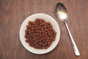 Chocolate corn balls in white plate and spoon