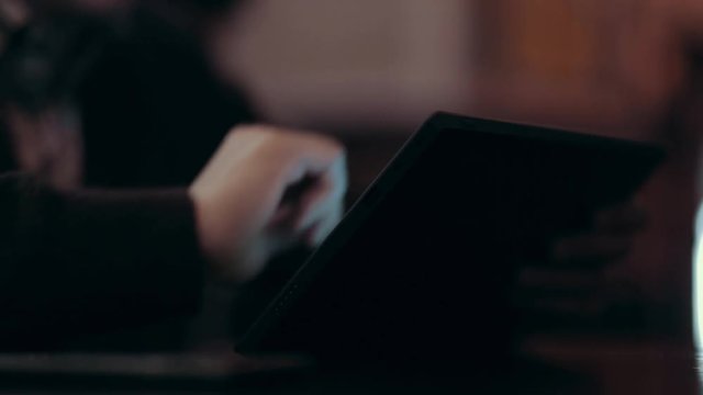 A young man makes a purchase from the online store sitting in a dark bar