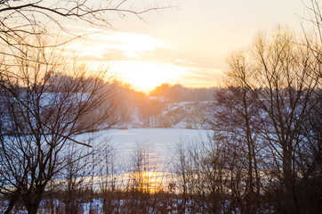 winter forest and the river at sunset