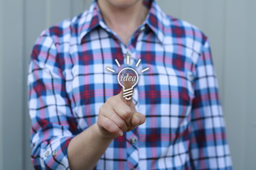 Businesswoman pressing bulb button on virtual screens. Ideas Innovation in business. Lightbulb, flask, idea, enlightenment, incandescent.