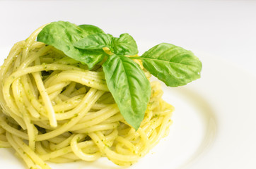 Italian pasta spaghetti with homemade pesto sauce and basil leaf