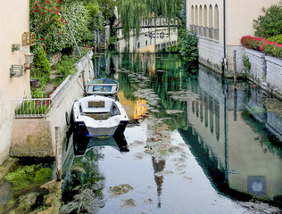 Kajakfahrer, Boote und Spiegelungen in einem Kanal in Sacile, Pordenone, Italien