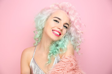 Trendy hairstyle concept. Young woman with colorful dyed hair on pink background