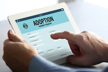 Adoption concept. Man filling in paternity form on tablet