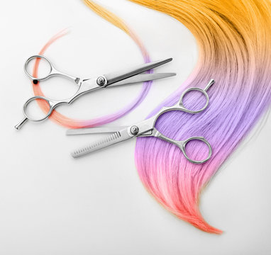 Trendy hairstyle concept. Colorful dyed hair and scissors on white background
