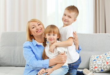 Happy grandmother with grandchildren on couch