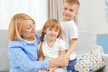 Happy grandmother with grandchildren on couch