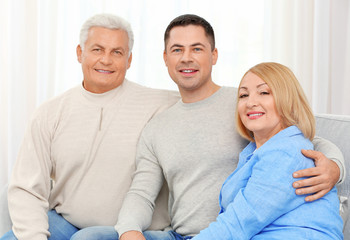 Adult son with parents on couch