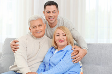Adult son with parents on couch