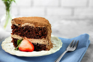 Slice of tasty chocolate cake with fresh strawberry on plate