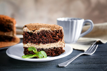 Tasty chocolate cake with tea on blurred background