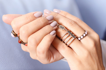 Close up view of female hands with beautiful manicure on blurred color background
