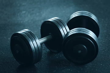 Two dumbbells on floor in gym, close up