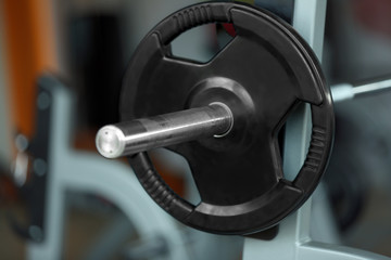 Barbell on rack in gym, close up