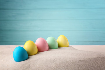 Easter eggs with sand, on wooden blue background