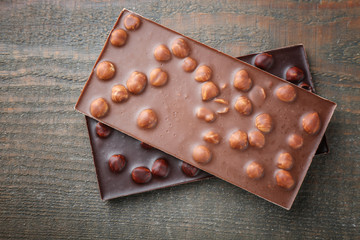 Chocolate bars with hazelnut, on wooden background