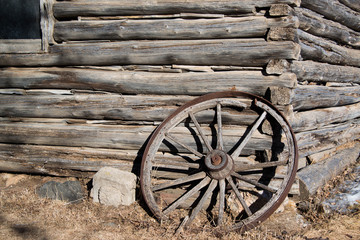 Fototapeta na wymiar Log Cabin with wagon wheel background