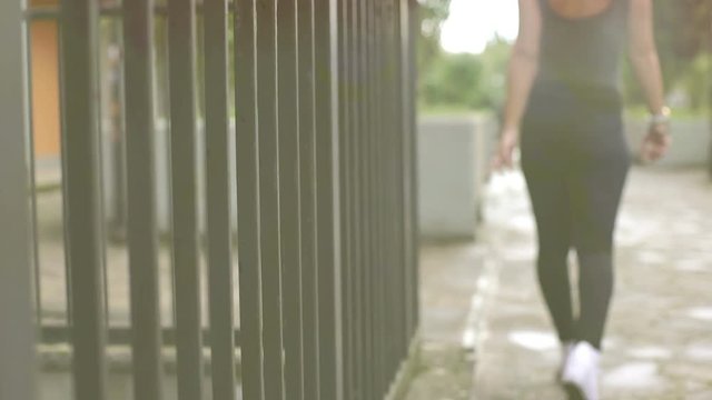 woman in love walking alone in the city stroking the bars of a building